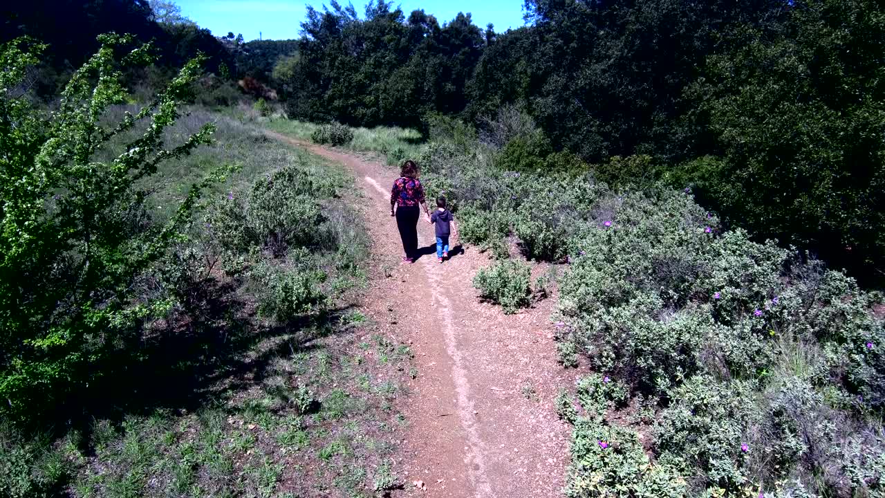 어머니 와 아들 이 시골 도로 를 고 있다