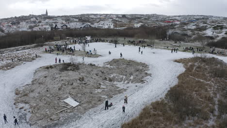 drone shot of people and families ice skating with his ice skates at öckerö island municipality in gothenburg archipelago, sweden