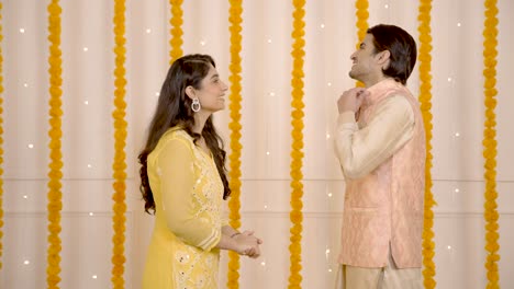 mujer india apreciando el atuendo de su marido