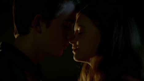 young couple sharing an intimate moment in low light