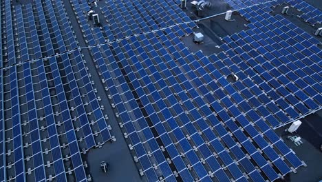 the aerial shot of solar panels on the roof of industrial building