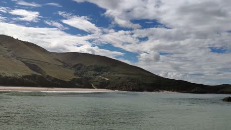 quiet bay view of torimbia beach with soft waves and hills in asturias, spain