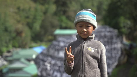 a male child on the way to everest base camp trekking smiles and poses in front of camera with awe and innocence, people of himalayas, a peaceful retreat on landscapes and lap of nature