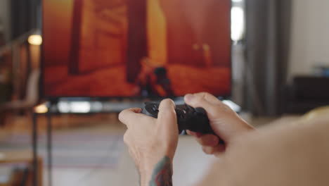 hands of man playing shooter game on tv at home