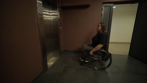 una mujer en silla de ruedas espera frente a un ascensor en un edificio, enfatizando la accesibilidad y la movilidad en la infraestructura pública. la imagen transmite independencia y diseño inclusivo para todos los usuarios.