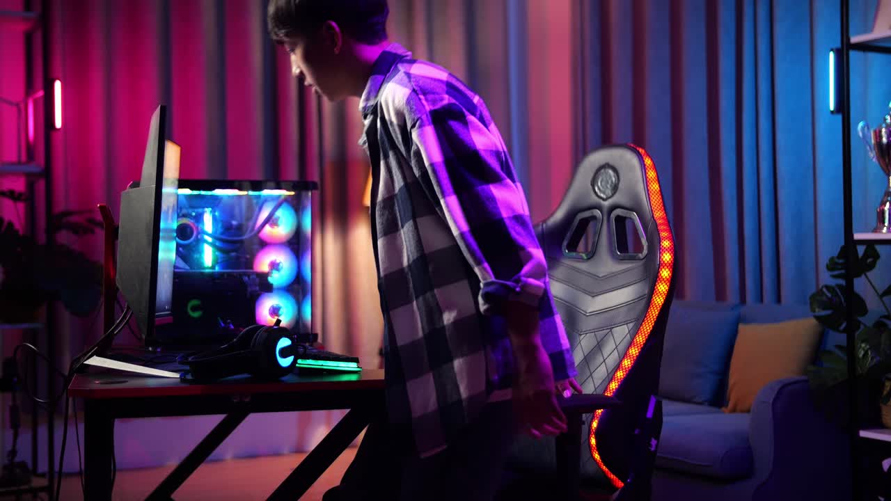 adolescente asiático sentado y comienza a jugar videojuegos en la computadora