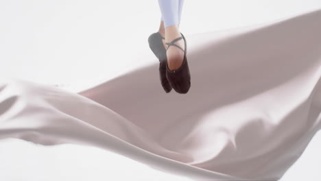 animation of caucasian female ballerina over floating cloth on white background