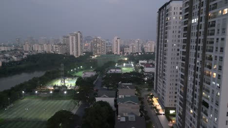 Drohnenschuss-Fliegt-Vorwärts-über-Das-Tran-thailändische-Wohngebiet-Des-Bezirks-Nha-Be,-Während-Die-Skyline-Von-Ho-Chi-Minh-Aus-Der-Ferne-über-Dem-Fluss-Rach-Dia-Zu-Sehen-Ist