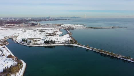 drone flying up from the frozen lakeshore of mississauga