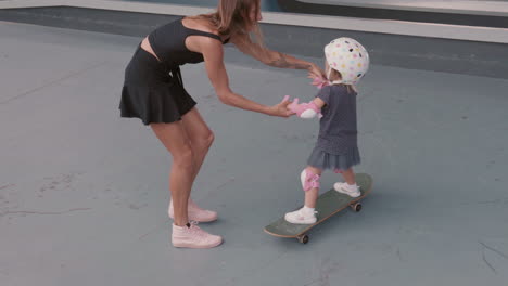 woman spending time with children in rollerblading arena