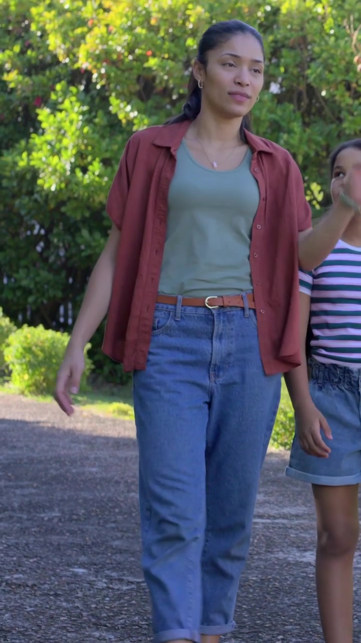 Video verticale: Mamma e bambina che camminano e parlano lungo un sentiero, la mamma con canotta verde e sandali, mentre la telecamera le segue.