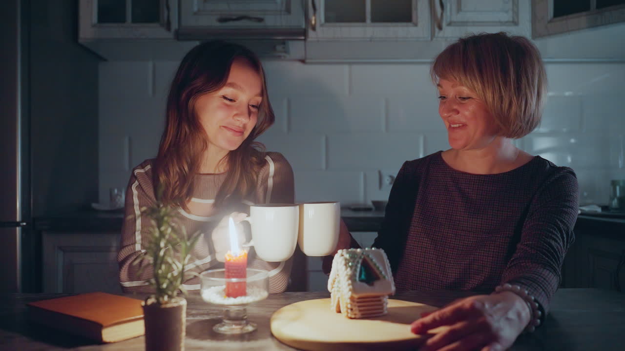 엄마는 따뜻하게 아이를 바라보고, 나무 트레이를 들고, 그들은 편안한 부, 불, 비 식물, 그리고 장식 된 케이크 집에서 행복하게 토스트를 만니다.