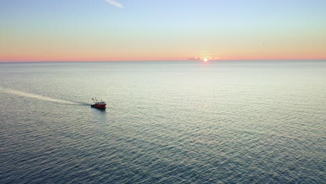 flying over seascape and lone trawler at sunset