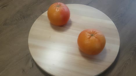 two oranges on round table that moves in a circle and waiting to be eat