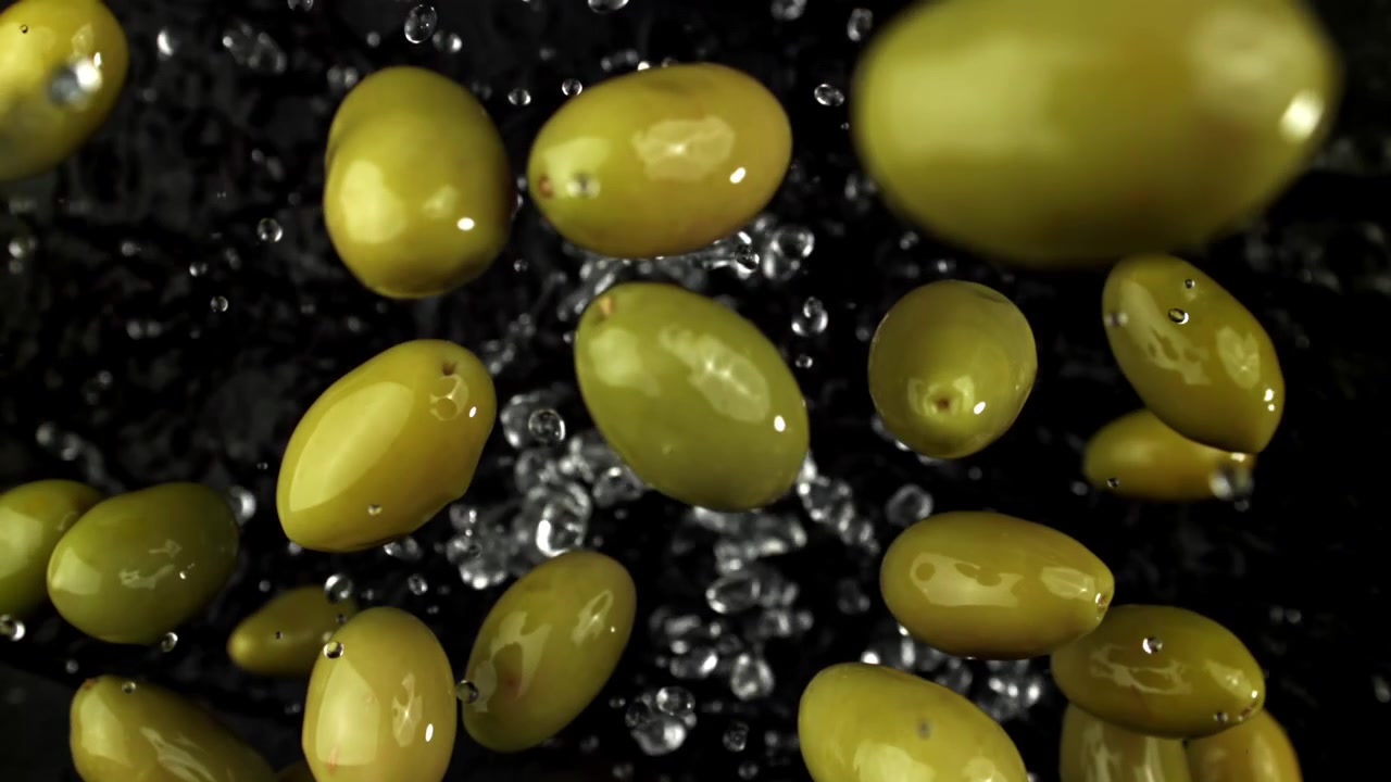 Olive verdi fresche che schizzano in acqua al rallentatore