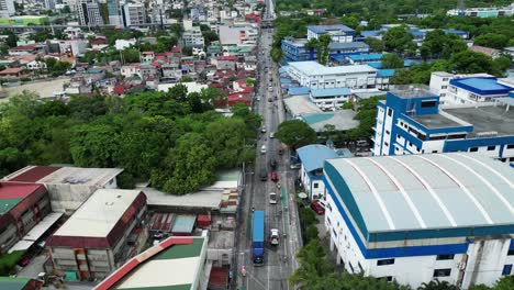 Aerial-shot-over-busy-highway-cutting-through-Manila,-Philippines