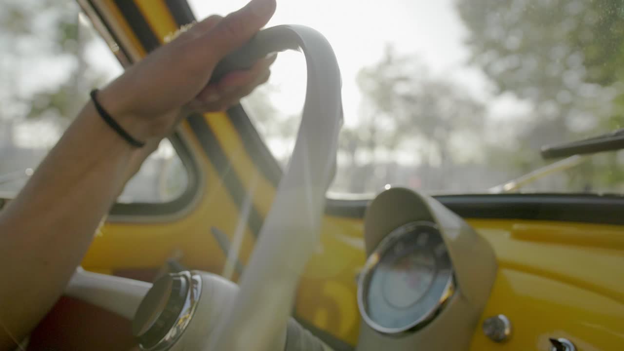 hombre conduciendo un coche clásico amarillo dentro del velocímetro del salpicadero durante el día cerrar