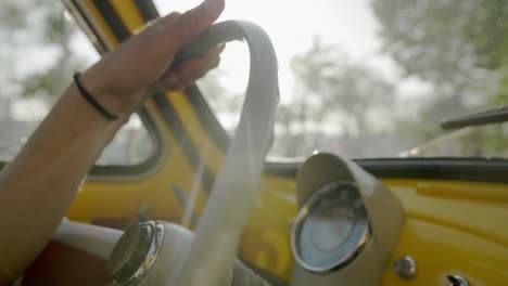 Hombre-Conduciendo-Un-Coche-Clásico-Amarillo-Dentro-Del-Velocímetro-Del-Salpicadero-Durante-El-Día-Cerrar