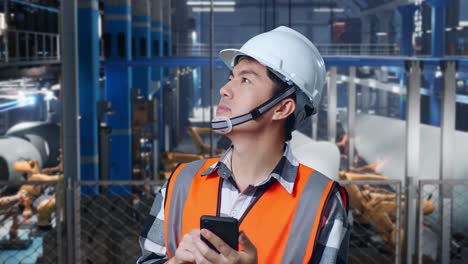 trabajador de fábrica que utiliza un teléfono inteligente en un entorno industrial