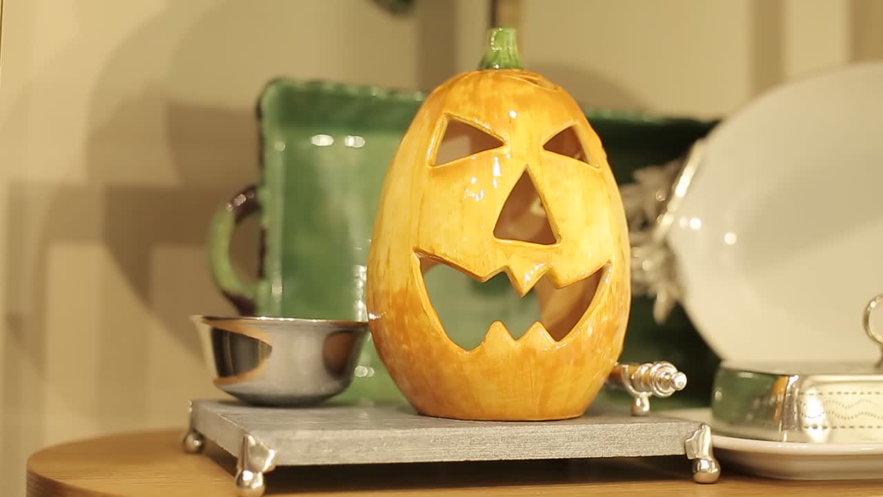 cabeza de calabaza en vidrio como decoración de mesa casera, celebración de halloween
