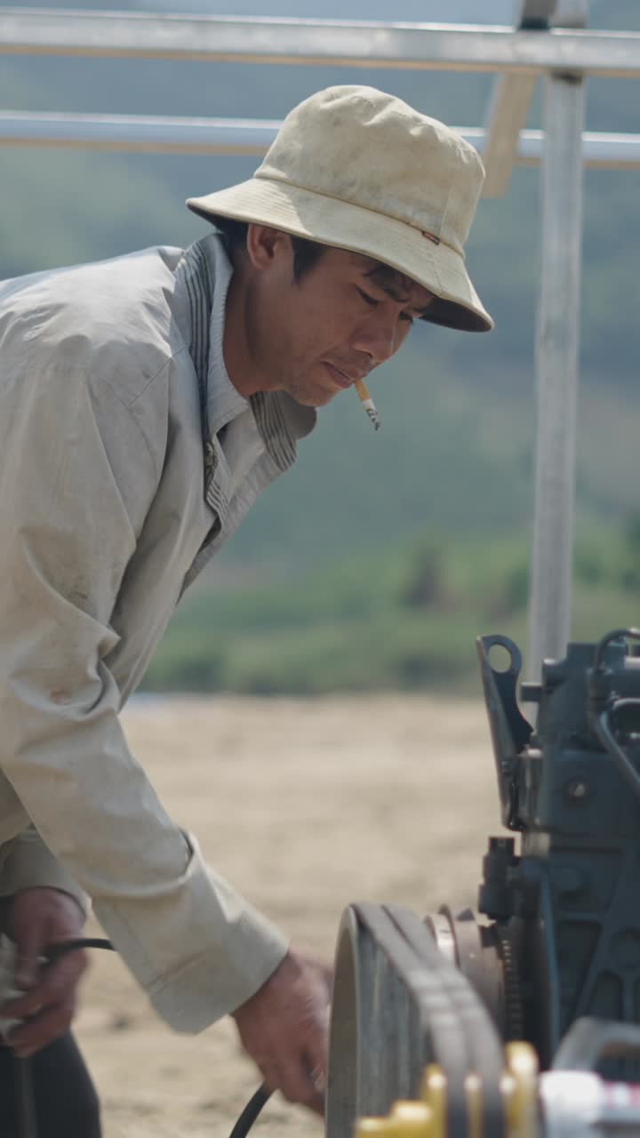 Man with cigarette working on machine