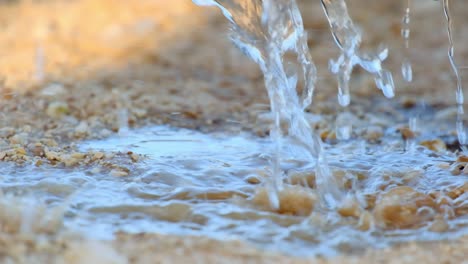 mucha agua saliendo de un recipiente de agua en medio de la tierra seca del desierto