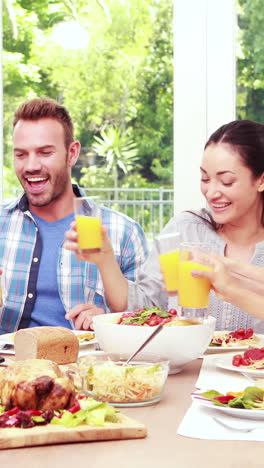 familia feliz brindando durante el almuerzo