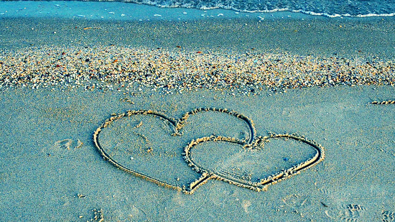Two hearts on the beach. The loving hearts
