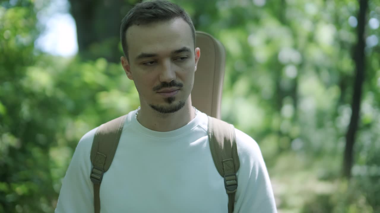 joven caminando con la guitarra en la calle cerca del bosque