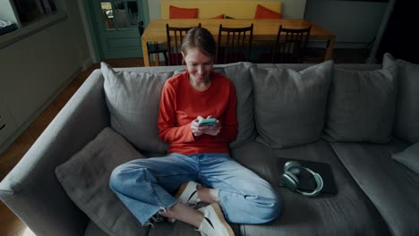 mujer relajándose en el sofá usando el teléfono móvil