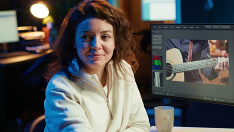 mujer alegre usando el ratón para editar imágenes de proyectos de películas en la oficina