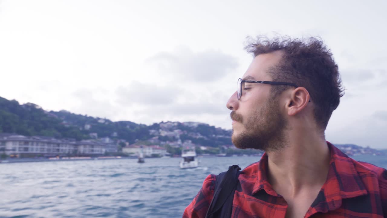 hombre observando la bandera turca y la ciudad desde el ferry. ciudad de estambul.