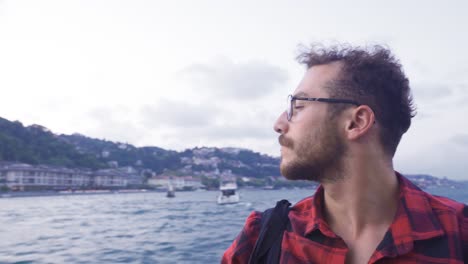 hombre observando la bandera turca y la ciudad desde el ferry. ciudad de estambul.