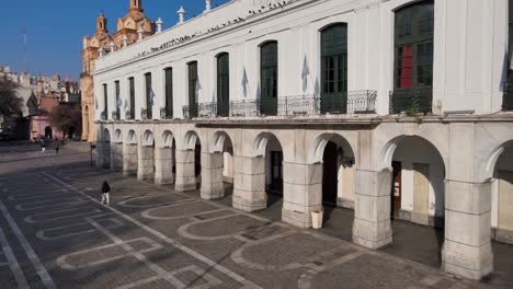 aerial pan shot capturing quiet square and cordoba cabildo colonial town hall with iconic arch passageway at san martin plaza in downtown city