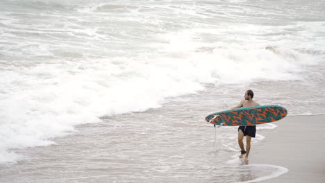 young athletic caucasian model male walking with surf