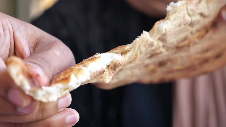 Hands tearing apart flatbread
