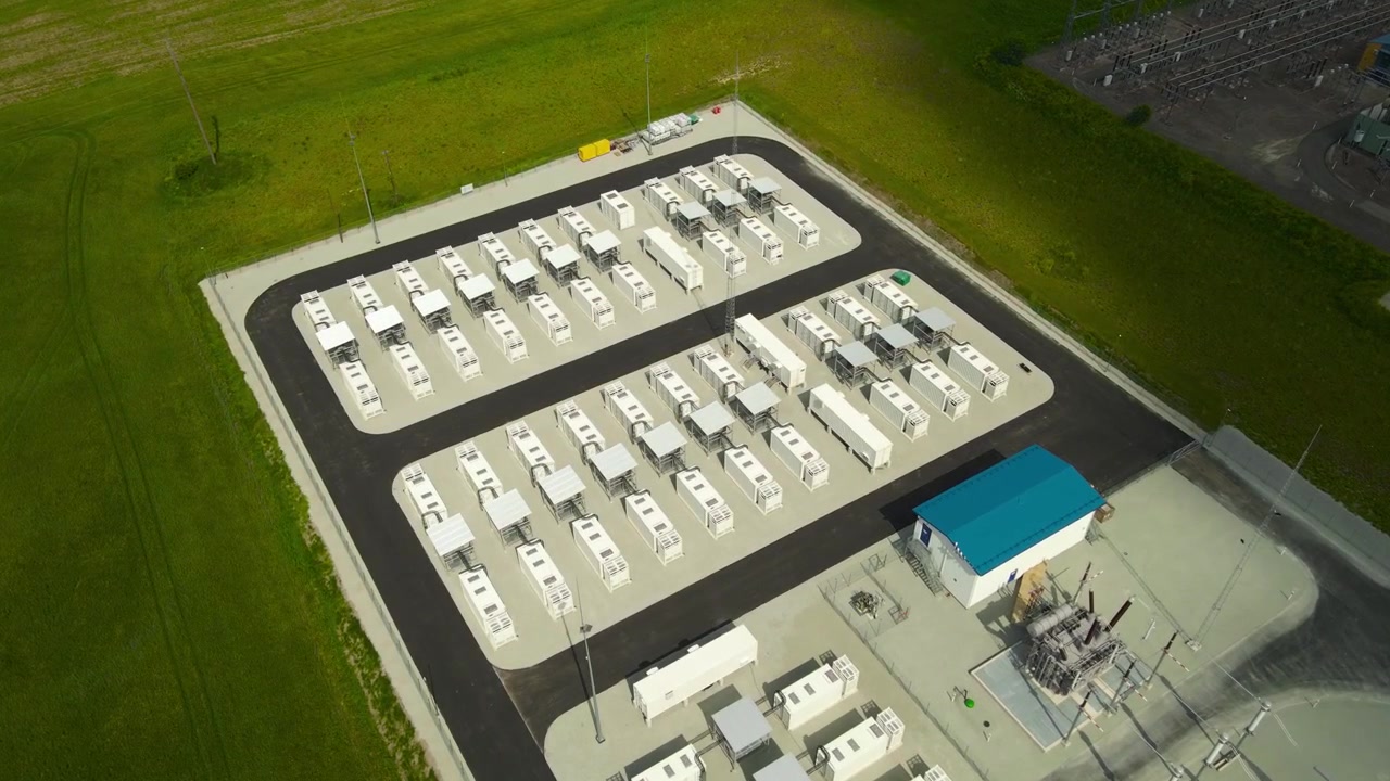 Moderne batterienergilagringsanlæg med lithium-ion-beholdere tilsluttet en højspændingselektrisk transformerstation, der leverer grøn strøm og understøtter elnettet med vedvarende energi