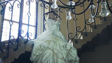 elegant close up of stunning wedding dress details on spiral staircase setting, reveal past stair handrail