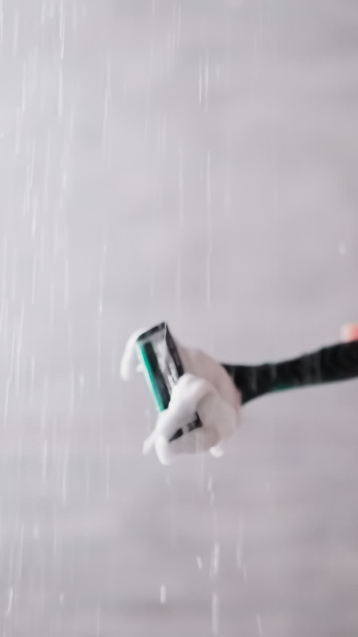 Woman cleans razor from foam in shower sprays closeup. Lady holds ...