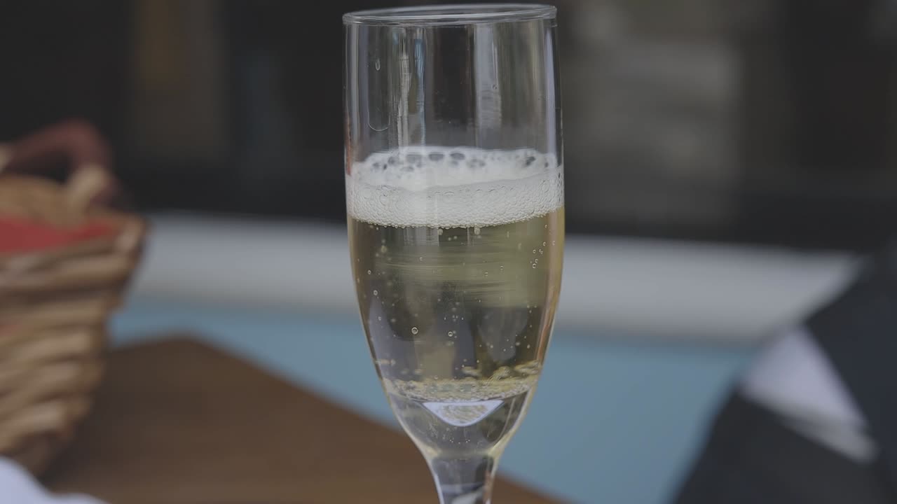 Primo piano di un flûte di champagne riempito con una bevanda frizzante
