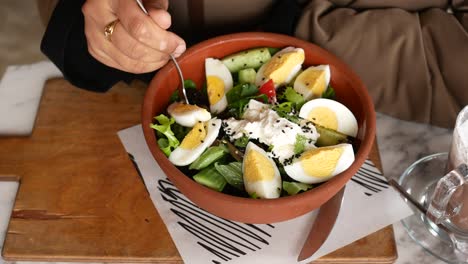 woman eating a healthy salad in a cafe