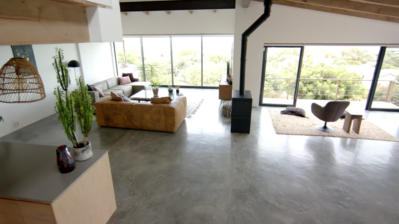 Modern living room with large windows, cozy seating area, and stylish decor