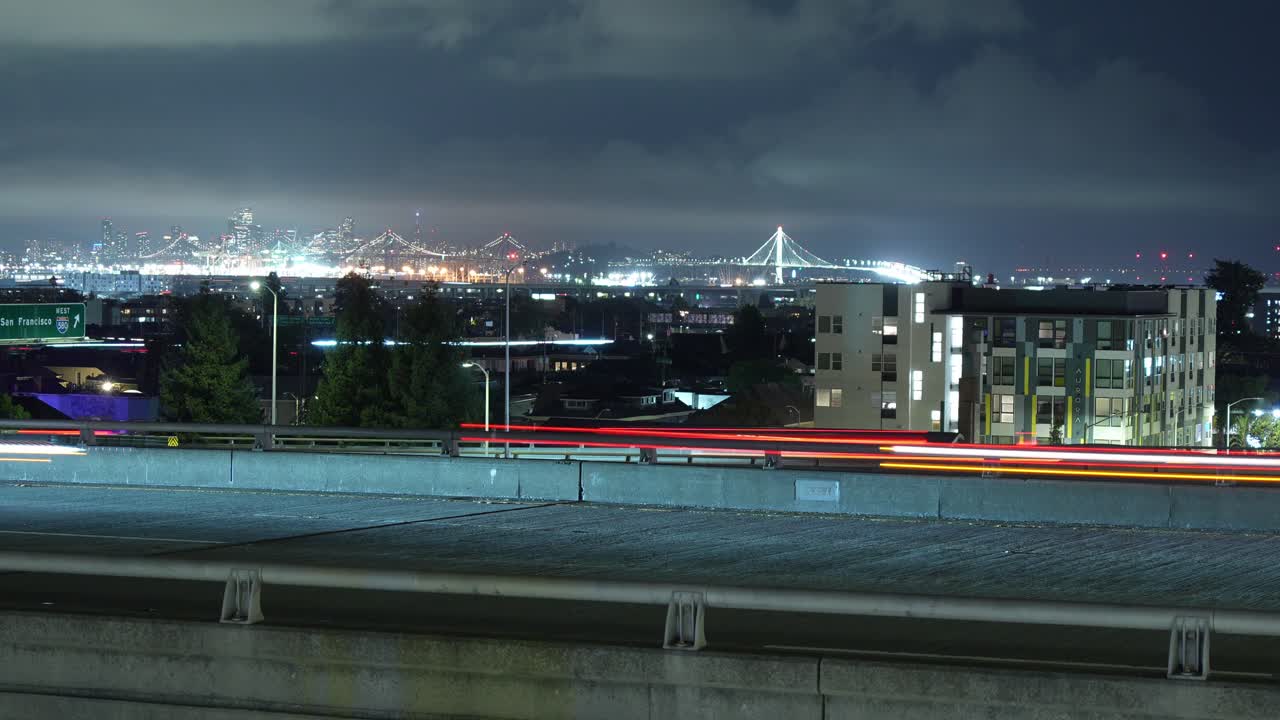 This time-lapse reveals the intricate layers of the MacArthur Maze in Oakland, with flowing traffic forming a web of light under the soft evening sky