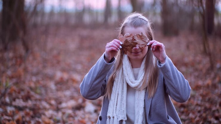 Smiling Woman Hiding Eyes With Leaves In Autumn 1