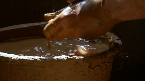 potter's hands wet their hands in water