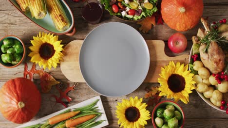 video of plate, diverse dishes and autumn decoration on wooden surface