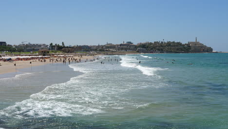 gente irreconocible disfrutando de la playa en tel aviv en un día soleado