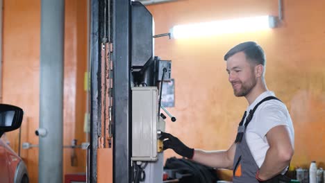 mechanic operating a vehicle lift in an auto repair shop