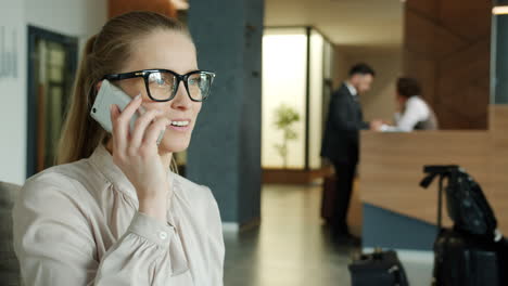 Businesswoman talking on phone in hotel lobby