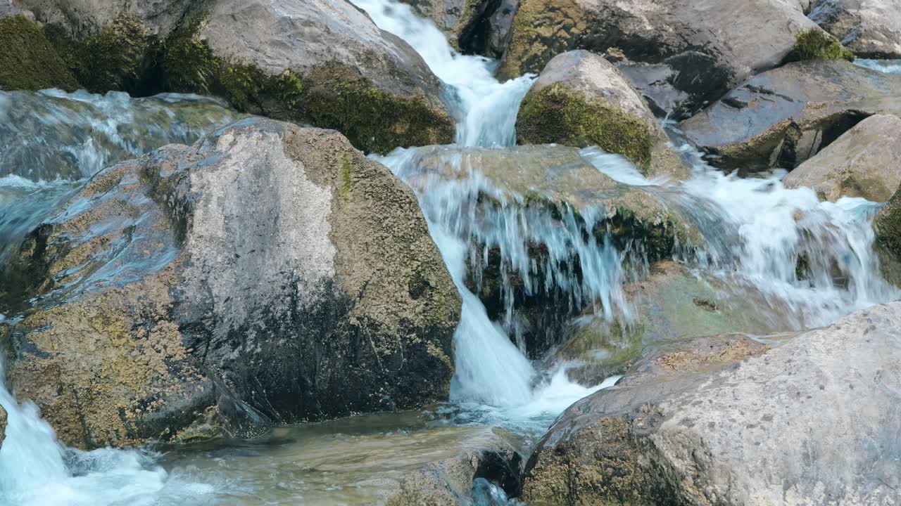 fuerte corriente de agua que fluye sobre las piedras en los alpes suizos